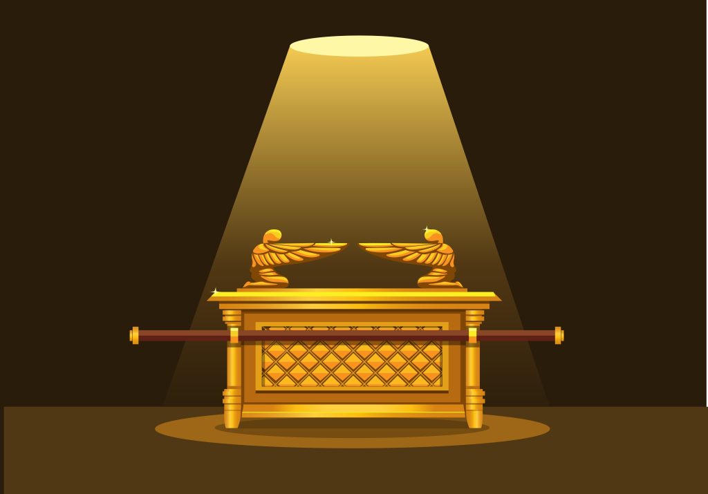 Golden ark under spotlight with cherubim figures.